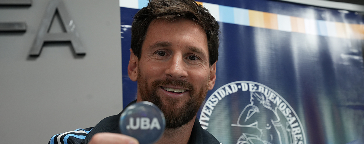 Messi con un pin en lamano que dice: UBA